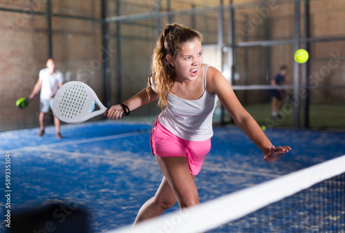 Athletic woman with passion plays padel