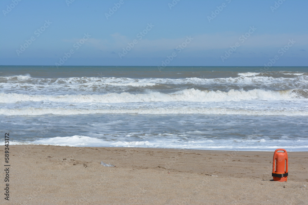 sandy beach, with the sea in the background and an orange lifeguard from the lifeguard sandy beach, with the sea in the background and an orange lifeguard from the lifeguard