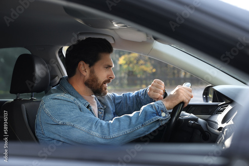 Foto Emotional man checking time on watch in car. Being late concept