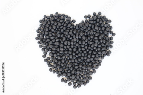 Plastic pellets for production, plastic polymer dye granules color black  on white background.