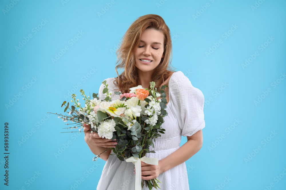 Beautiful woman with bouquet of flowers on light blue background Beautiful woman with bouquet of flowers on light blue background