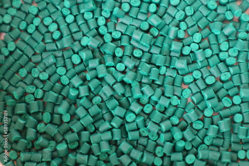 Primary color mix. Green plastic pellets, rubber granules on a white background