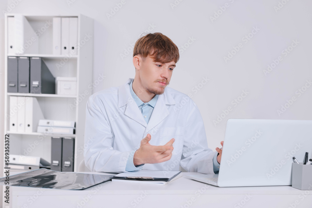 Doctor consulting patient on laptop at table in clinic. Neck MRI Doctor consulting patient on laptop at table in clinic. Neck MRI