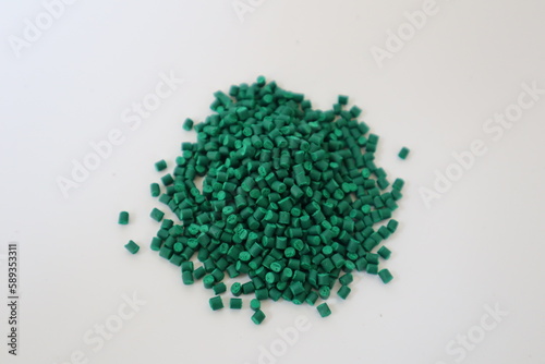 Primary color mix. Green plastic pellets, rubber granules on a white background