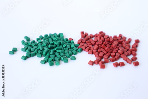 Primary color mix. Green plastic pellets, rubber granules on a white background
