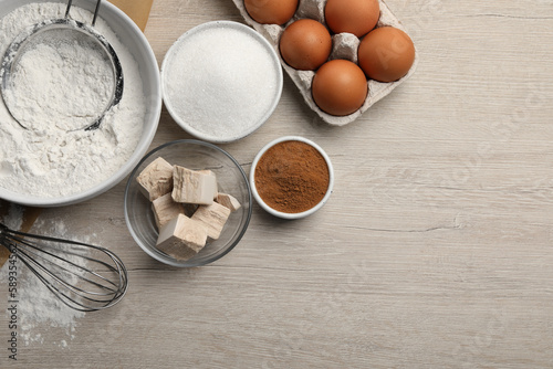 Flat lay composition with flour, yeast cake and different ingredients on white wooden table, space for text. Making pie