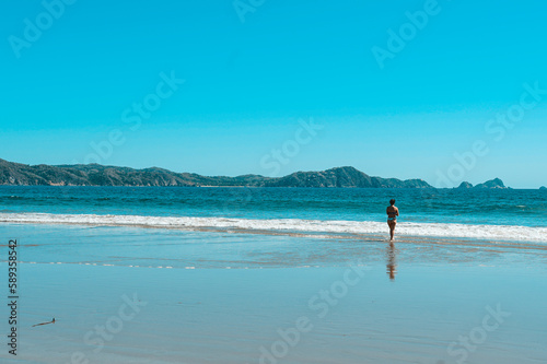Mujer sola en la playa observando el mar photo