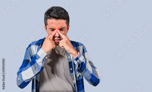 Man with nasal bridge pain, Man with nasal bridge headache. Sinus pain concept. Young man with pain when touching his nose