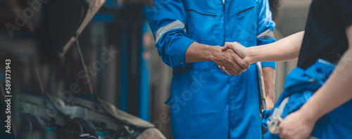 Car mechanic, professional technician shake hands in car repair success engine care Check the condition for customers who come to use the service at the center and are entrusted with the service.