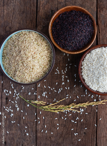 Closeup Brown rice, Black Jasmine rice, and Rice berry in bowl on wooden desk.