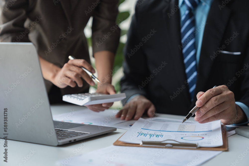 Business team working at office with laptop and calculator to calculate graph data sheet. Numerical charts that display financial budgets, investments, project plans, joint operations. Business team working at office with laptop and calculator to calculate graph data sheet. Numerical charts that display financial budgets, investments, project plans, joint operations.