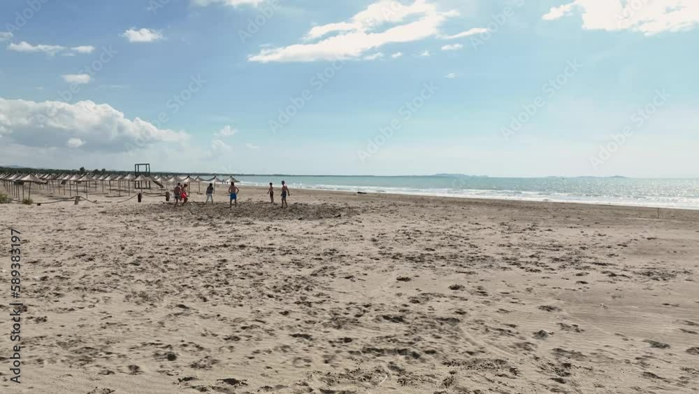 Aerial shot group of teenager playing with ball on an empty sandy beach Aerial shot group of teenager playing with ball on an empty sandy beach