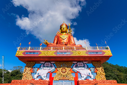 Holy statue of Guru Padmasambhava or born from a lotus, Guru Rinpoche, was a Indian tantric Buddhist Vajra master who taught Vajrayana in Tibet. Blue sky and white clouds, Samdruptse, Sikkim, India.