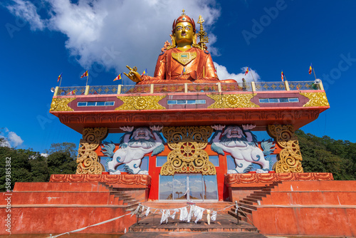 Holy statue of Guru Padmasambhava or born from a lotus, Guru Rinpoche, was a Indian tantric Buddhist Vajra master who taught Vajrayana in Tibet. Blue sky and white clouds, Samdruptse, Sikkim, India.