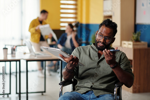 Portrait of entrepreneur recording voice message for coworker after analyzing chart