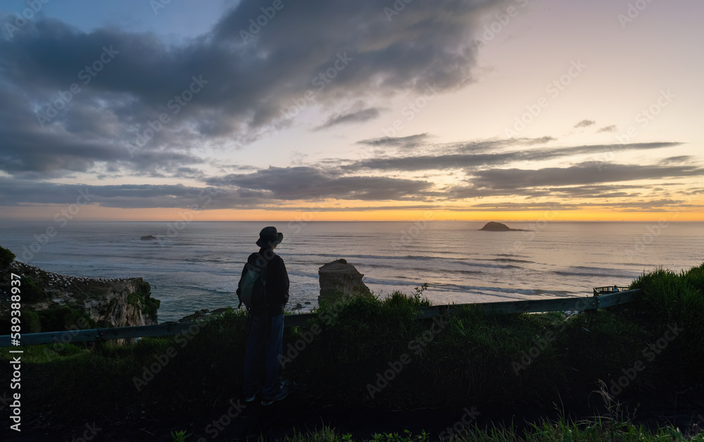 Man watching sunset at Muriwai Beach Gannet Colony. Auckland.