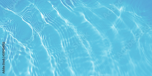 Water waves surface hits the sunlight. Close up swimming pool water background. Transparent water surface.