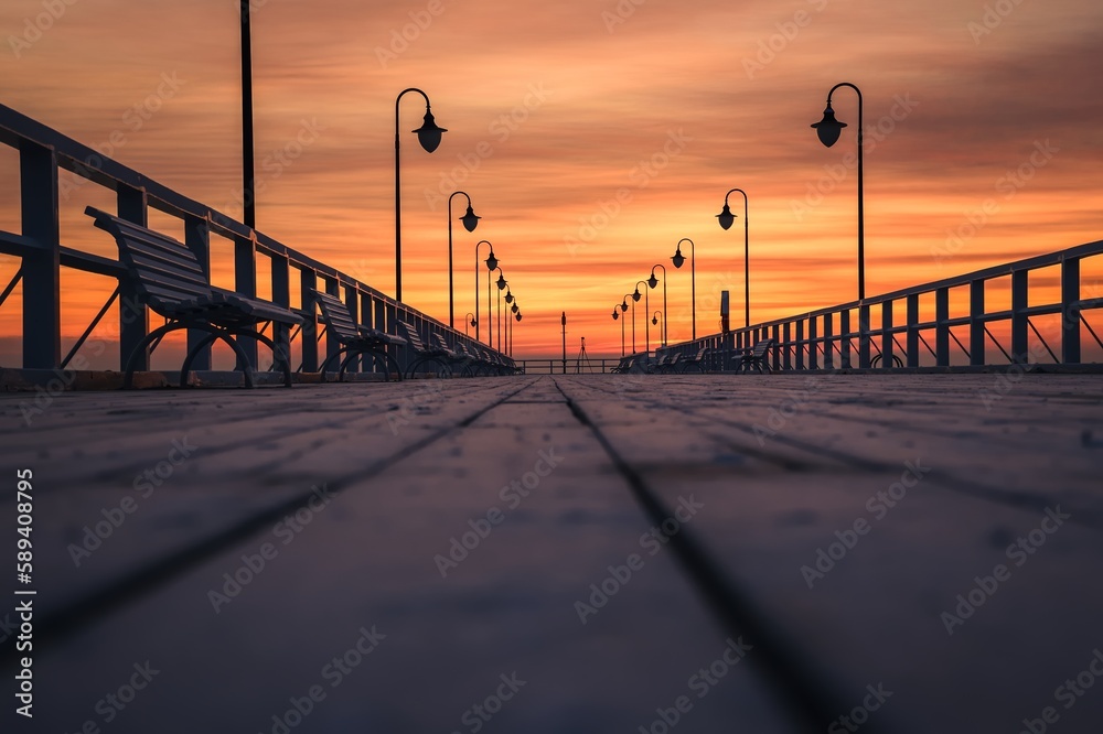 Beautiful sunrise over the Polish sea. Popular pier on the Baltic Sea at sunrise. Shallow depth of field photo with foreground blur effect.