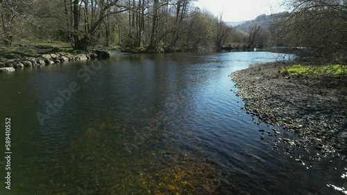 River Rothay slow motion with distant swan swimming near Rydal Water in the English Lake District Cumbria photo