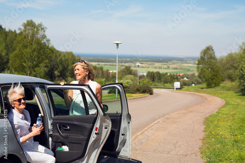 Two senior women with their car on rural road