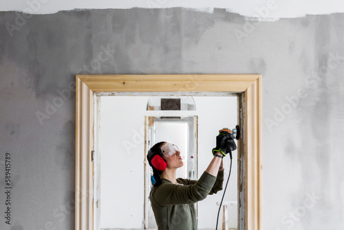 Woman polishing door frame during renovation