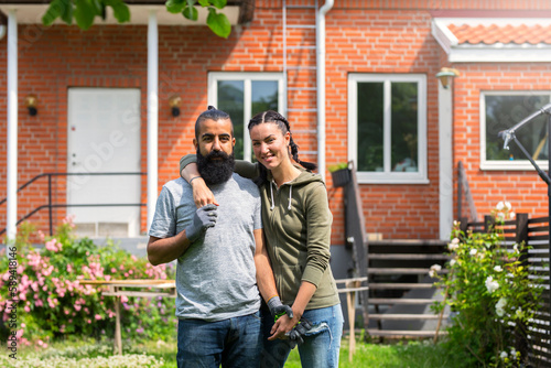 Portrait of couple standing in front of house