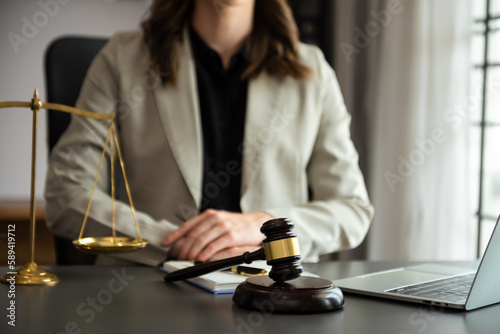 justice and law concept.law theme wooden desk, books, balance. Male judge in a courtroom the gavel,working with digital tablet computer on table..