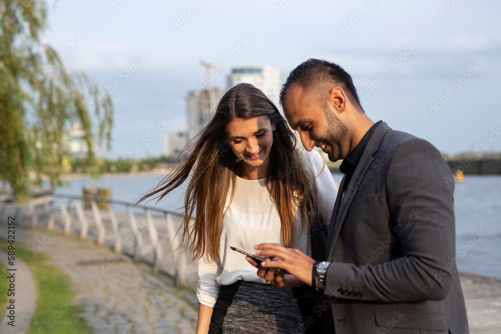 Smiling man and woman using phone Smiling man and woman using phone