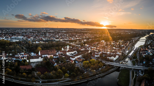 Panorama der Stadt Regensburg in Bayern mit dem Fluss Donau dem Dom und der steinernen Brücke im Herbst während Sonnenuntergang, Deutschland photo