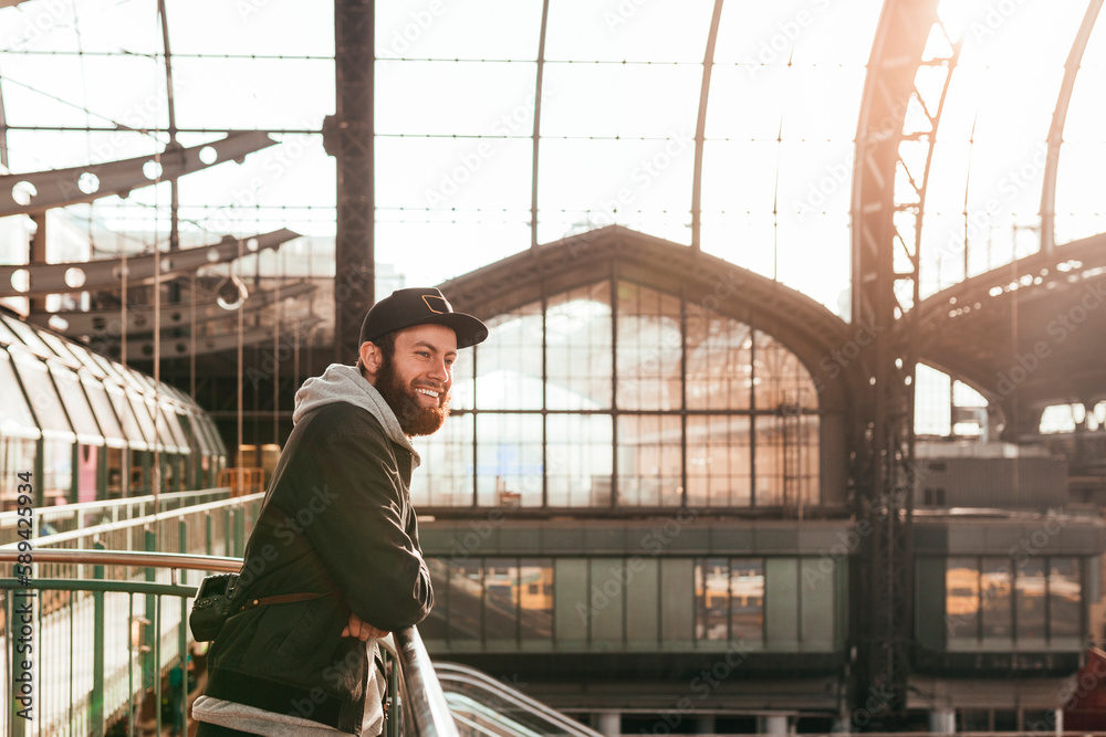 Young man leaning on railing at train station Young man leaning on railing at train station
