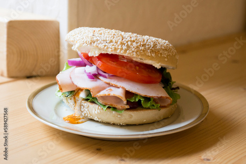 Delicious turkey sandwich on bagel bread. A bagel is a bread traditionally made from wheat flour and usually has a hole in the center. photo