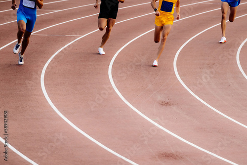 group stayer runners running middle distance race on turn track  stadium, summer athletics championships photo