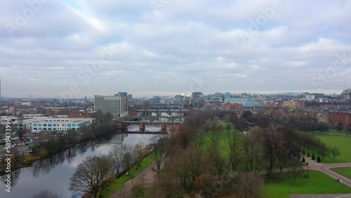 Aerial shot of urban river and city skyline rising above trees, Scotland photo