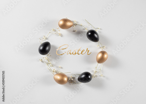 Flat Lay of Golden and Black Easter Eggs ring circle on white background decorated with flowers. Easter background or easter concept. Still life