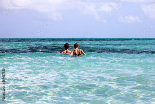 Couple swimming in azure sea water. Man with woman together, beach vacation © Oleg