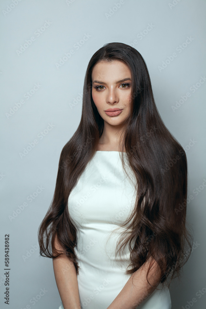 Attractive lady in white silky dress posing. Elegant fashion model with long straight hair portrait Attractive lady in white silky dress posing. Elegant fashion model with long straight hair portrait