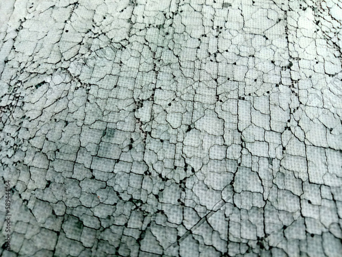 Synthetic rubber fabric surface has many cracks, light blue color.