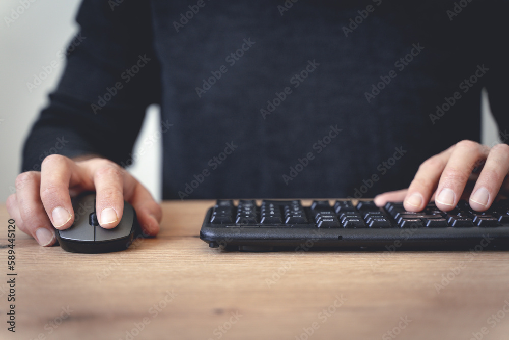 User uses the computer at the desktop in the office or at home. Business, study, technology concept. User uses the computer at the desktop in the office or at home. Business, study, technology concept.