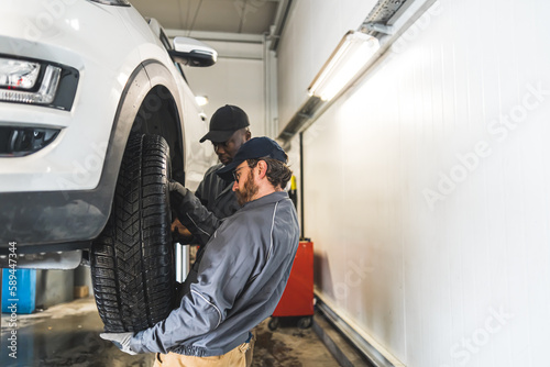 professional mechanics changing a wheel on the car  car repair concept. High quality photo