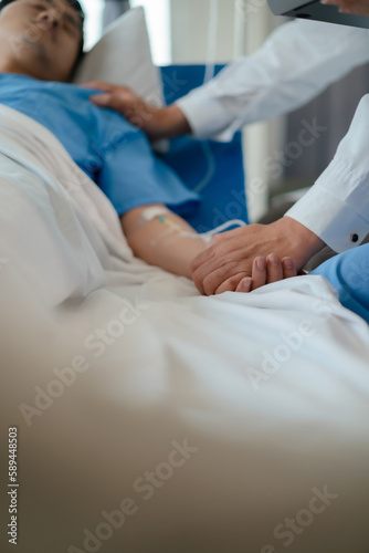 doctor check up after surgery. doctor touching patient hand and consoling.