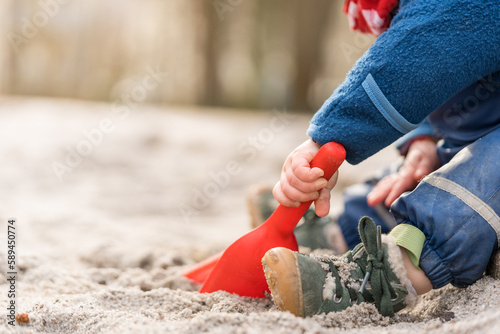 Cutout of toddler playing in sandbox