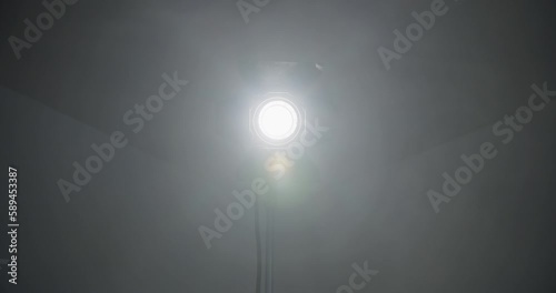 Video studio Fresnel lens spotlight on black background. lights slowly turn on and off. Close up.