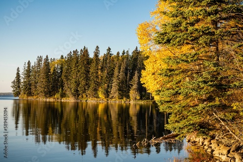 Lush autumn trees on the shore of a lake in Prince Albert National Park, Saskatchewan photo
