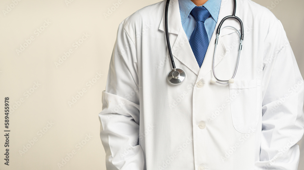 Doctor in uniform with a stethoscope while standing against a gray background Doctor in uniform with a stethoscope while standing against a gray background