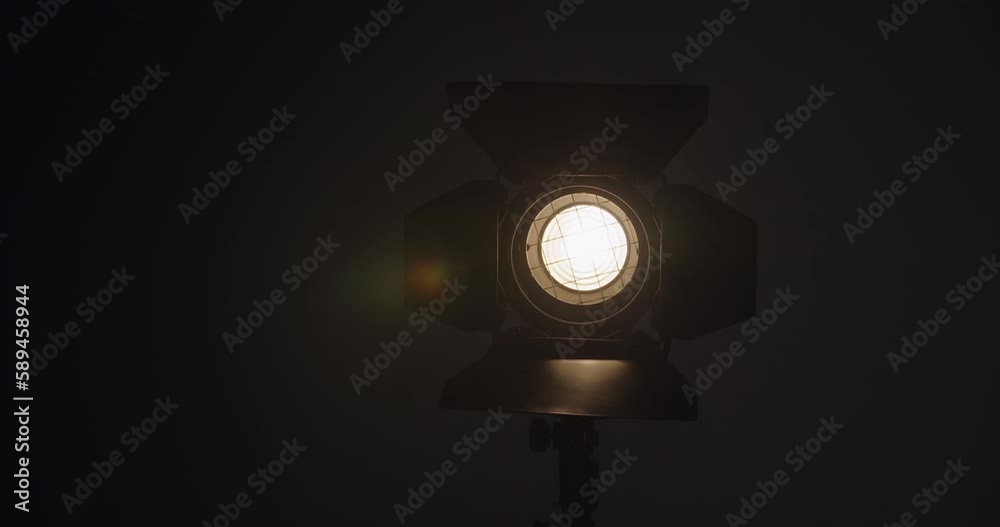 Video studio Fresnel lens spotlight on black background. lights slowly turn on. Close up. Video studio Fresnel lens spotlight on black background. lights slowly turn on. Close up.