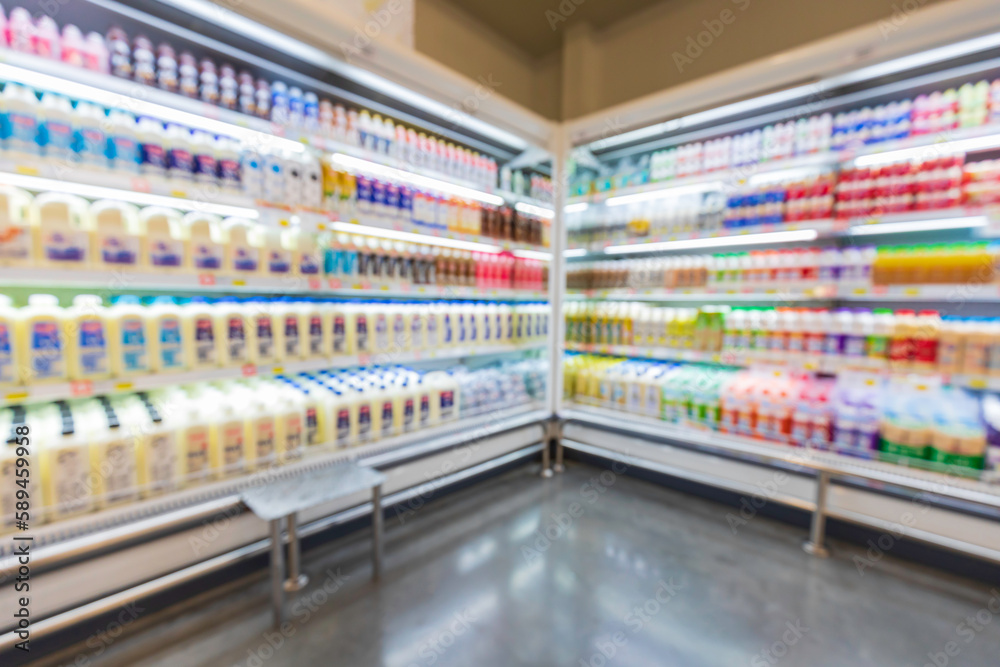 The defocused blur of supermarket drink shelves with dairy products. Blur background with bokeh.
