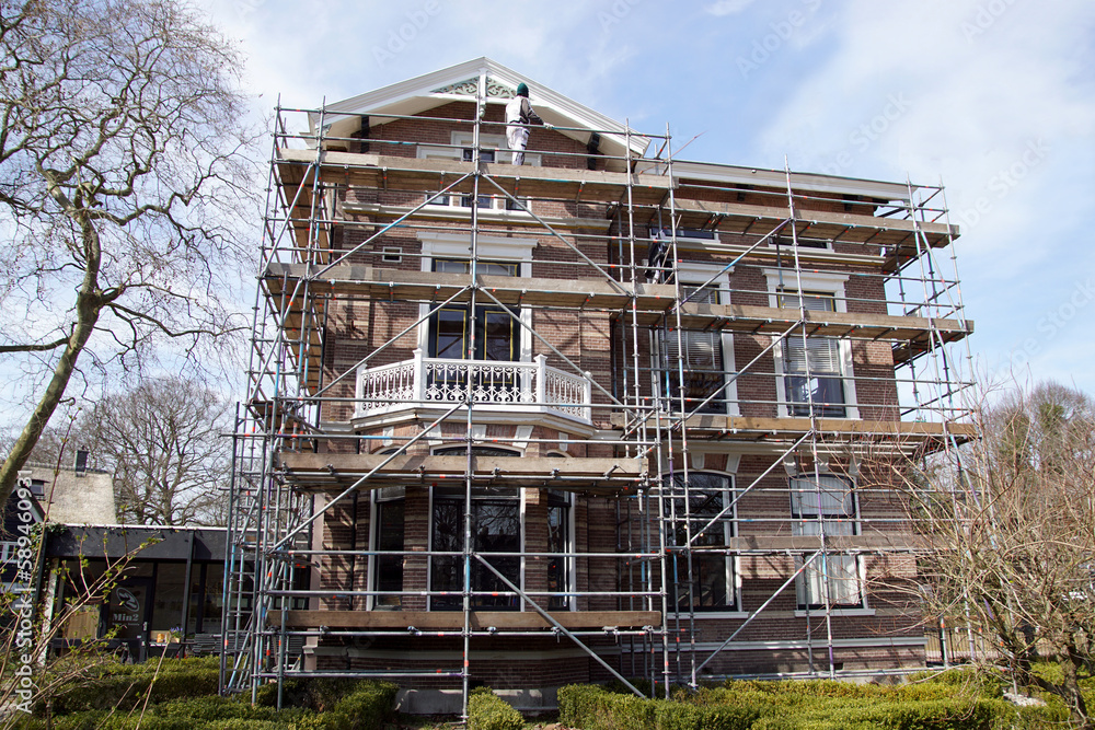 Historic villa (1885) in Bergen, North Holland in the scaffolding to be painted. April, Netherlands
