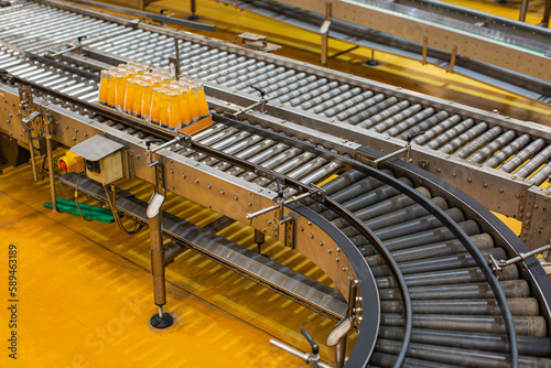 Beverage factory interior. Conveyor flowing with bottles for juice