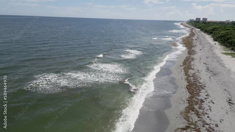 Drone view of Atlantic Ocean waves touching the sandy shoreline on a sunny day in Florida Drone view of Atlantic Ocean waves touching the sandy shoreline on a sunny day in Florida