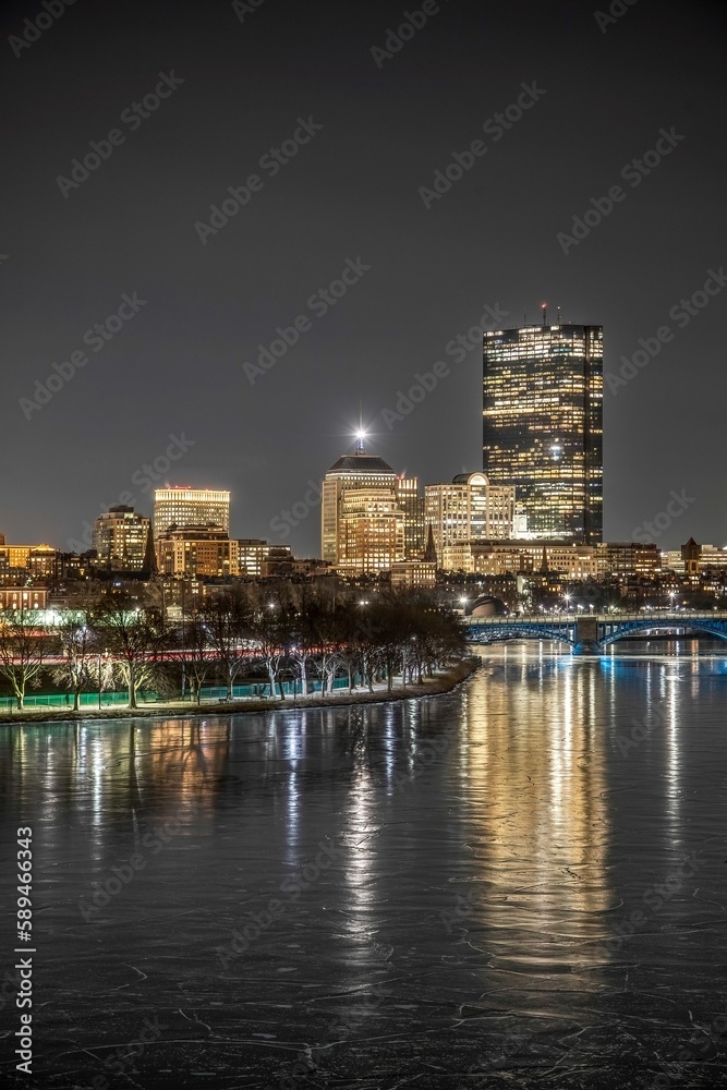 Obraz premium the night time skyline is reflected in the water of the city